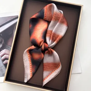 Close-up of orange and grey leopard pattern silk scarf with elegant drape and fine seams