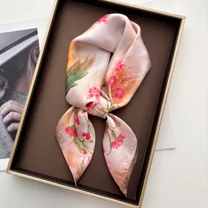 Dettaglio di un foulard in seta rosa con stampa floreale in scatola regalo