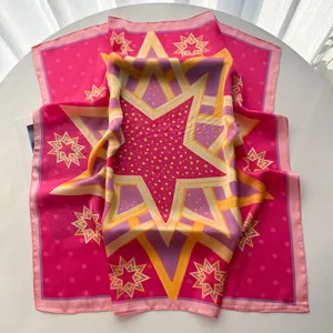 Detail eines fuchsia Seidenquadrats mit leuchtend gelbem Sternmuster auf weißem Grund