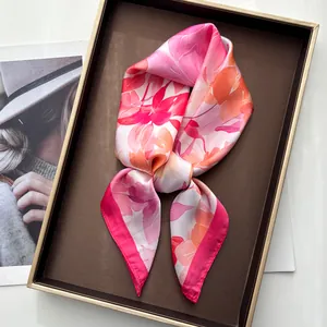 Close-up of elegant watercolor peony print silk scarf on a luxury leather tray