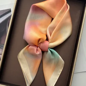 Carré de soie élégant dégradé rose et orange présenté dans un coffret cadeau raffiné