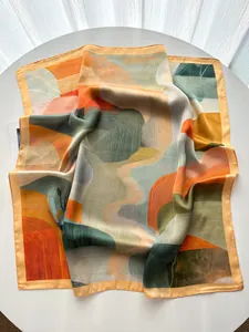 Detail of elegant satin scarf showing abstract landscape print and smooth silk texture