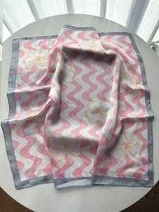 Detailed texture of wavy pink floral silk scarf with elegant satin finish on a table