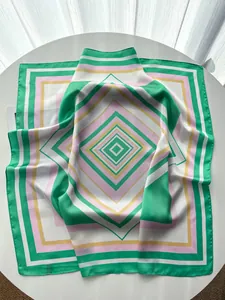 Detail of square silk scarf showing geometric striped patterns and premium rolled edges