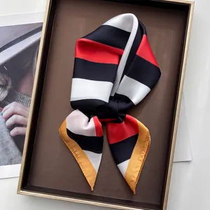 Detail of striped silk square scarf with bold red and black contrast on a display tray