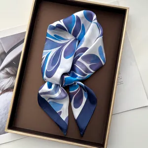 Close-up of silk neckerchief with leaf patterns tied in a bow on a display tray