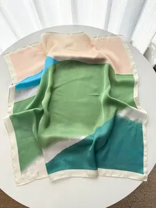 Detailed close-up of color-blocked landscape print silk square scarf with soft folds
