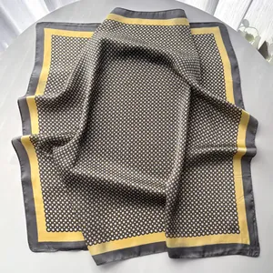Détail de foulard en soie à motif chaîne géométrique avec bordure contrastée et plis