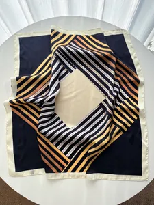 Détail d'un foulard en soie brillant avec rayures géométriques et dégradé de couleurs