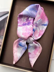 Detailed close-up of a floral silk scarf with pink peony watercolor print in a tray