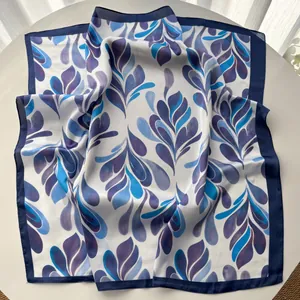 Detail of silk-like square scarf featuring elegant blue and purple leaf print textures