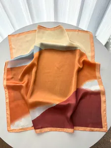 Detailed view of abstract geometric satin scarf with orange and red color blocking
