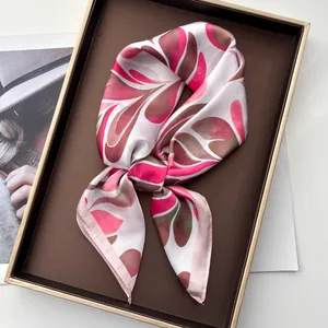 Close-up of pink and brown silk scarf with leaf pattern in a premium gift box