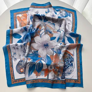 Dettaglio foulard in seta con stampa floreale di magnolia e bordi blu e arancioni di lusso