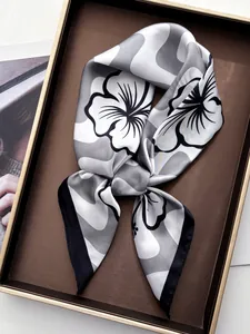 Detail showing wavy floral print silk scarf displayed elegantly in a tray