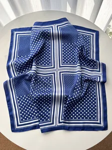 Detail of navy blue and white polka dot silk square scarf with elegant stitching