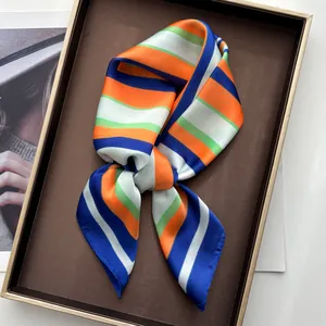 Detail of silk-like scarf tied in a bow with vibrant blue and orange stripes