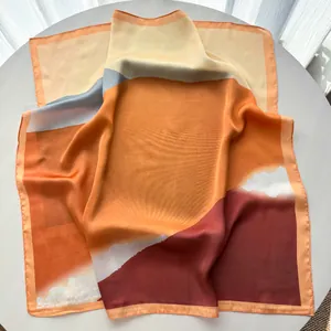 Detailed macro view of satin silk square scarf showing color block patterns and texture