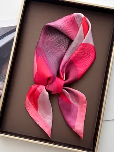 Detailed view of an elegant silk scarf with abstract pink and purple geometric patterns
