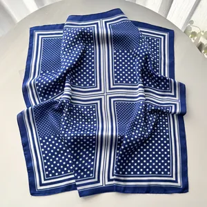 Detail of blue and white polka dot silk scarf with smooth edges on a white table