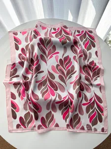 Detailed view of satin silk square scarf with pink paisley leaves and smooth texture