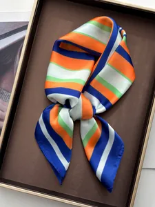 Close-up of vibrant striped silk scarf tied in a knot on a brown display tray
