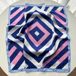 Detail of silk-like square scarf featuring navy blue and pink geometric stripe patterns