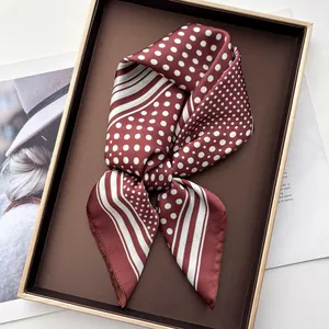Close-up of wine red polka dot silk scarf in a premium gift box with fashion magazine