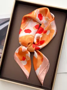Detail eines eleganten Seidenschals mit orangefarbenem Leopardenmuster im Goldtablett