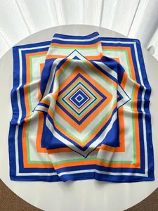 Detailed view of striped geometric silk scarf with bold colors on a white table