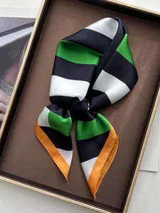 Detail of silk-like scarf with green and black bold stripes and orange rolled edges