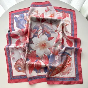Dettaglio di un foulard in seta con stampa floreale di magnolia e motivi di melograno