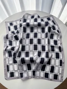 Detail eines seidenähnlichen Satin-Vierecktuchs mit modernem schwarz-weißem Geometriemuster