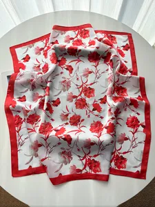 Detailed view of red carnation silk scarf texture and elegant floral pattern on table
