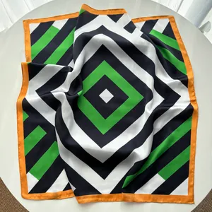 Detail of silk satin square scarf with green black geometric stripes and orange edges