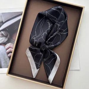 Detailed close-up of a floral silk scarf tied in a bow on a luxury display tray