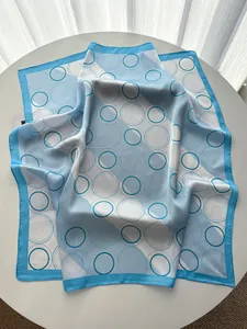 Detail of blue geometric circle pattern square silk scarf on a white table