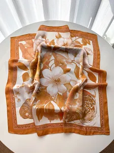 Dettaglio di un foulard in seta con stampa di magnolia francese su un tavolo bianco