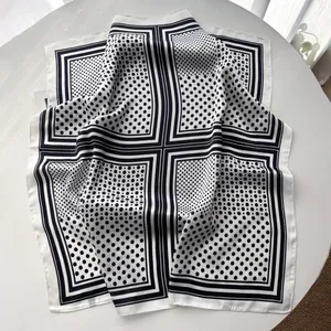Macro detail of silk-like square scarf featuring retro black and white polka dot pattern