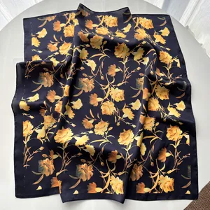 Detail view of floral carnation print on elegant black silk scarf with soft texture
