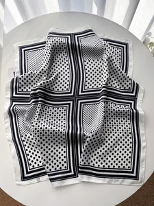 Detail of elegant black and white polka dot silk scarf with smooth satin texture