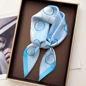Detail of blue and white geometric silk scarf elegantly tied in a luxury gift box