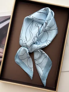 Detailed view of light blue floral silk scarf with black line art and hand-rolled edges