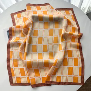 Detailansicht des Seidenschals mit orangefarbenem geometrischem Muster und braunem Rand