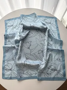 Detailed view of French vintage floral silk scarf with magnolia print on a white table