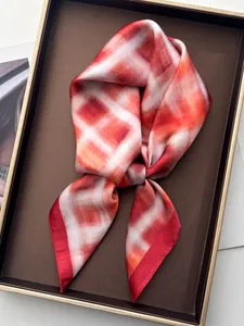 Macro detail van rood-witte geblokte zijden sjaal in een luxe geschenkverpakking geplaatst