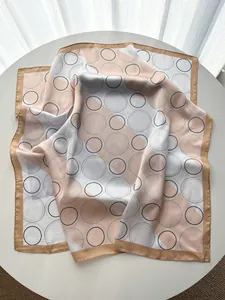 Detail of geometric circle patterns and champagne gold satin borders on silk scarf