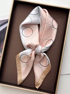 Detail of silk-like geometric square scarf with satin finish and rolled edges in gift box