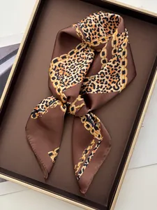 Gros plan d'un foulard en satin imprimé léopard et chaînes dorées aux tons bruns