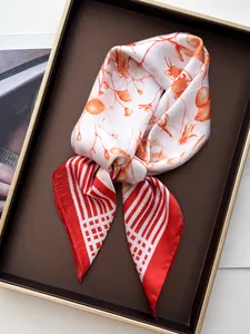 Close-up of elegant silk scarf tied in a bow with floral print and vibrant orange stripes